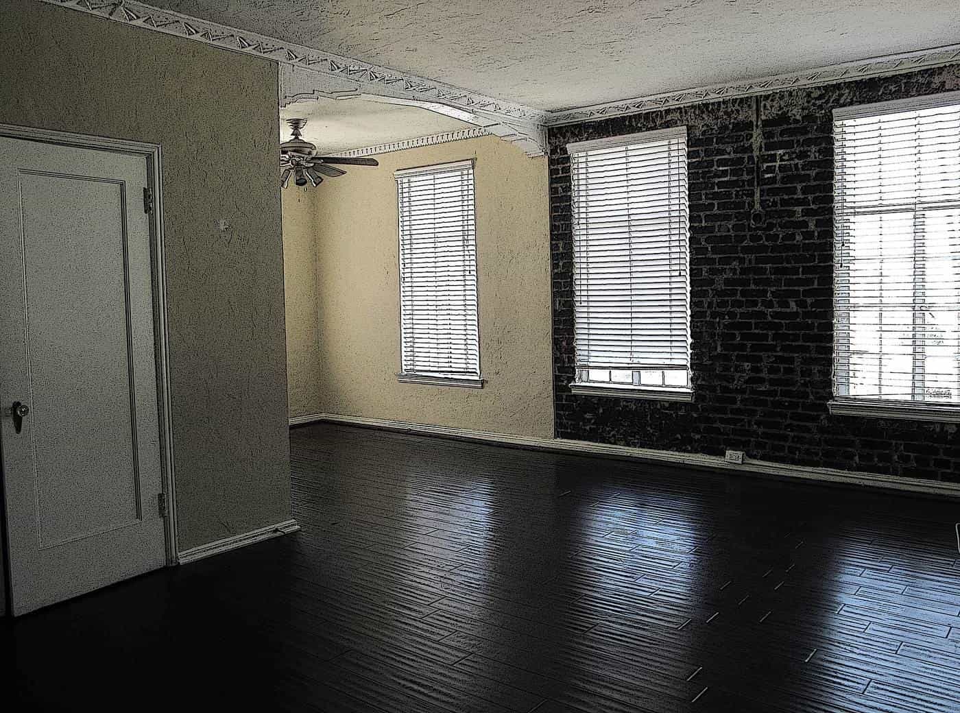 An empty apartment living room with dark floorboards
