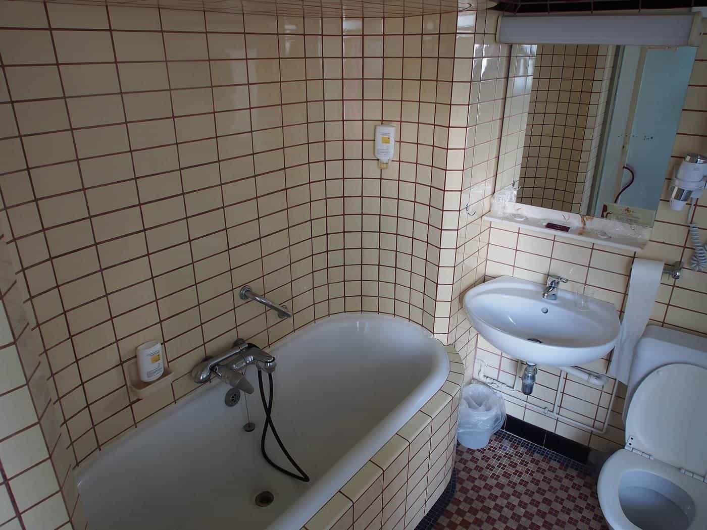 An old bathroom with white subway tiles