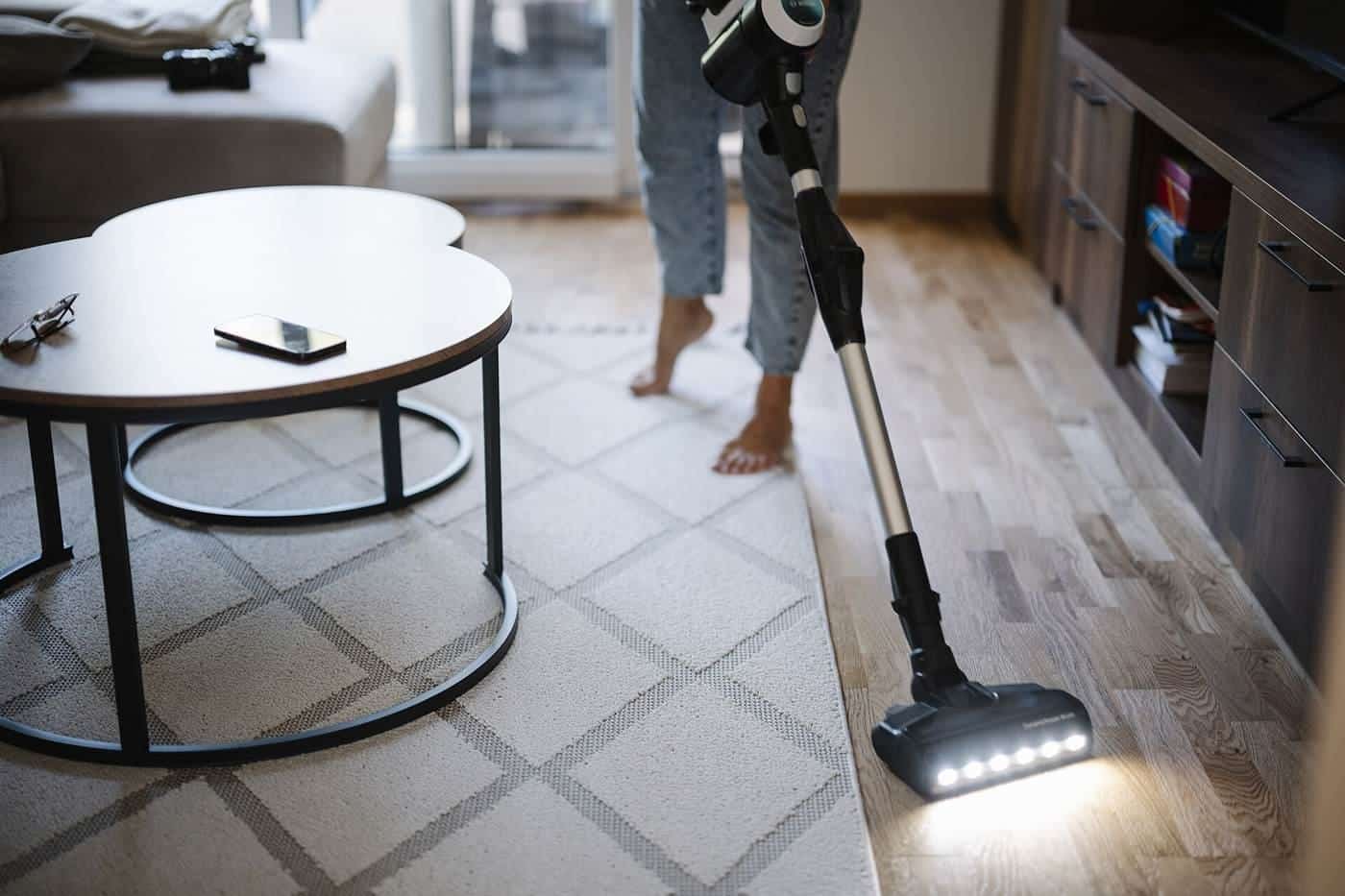 A person vacuuming a living room floor